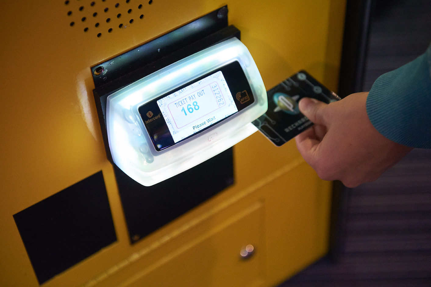 Photo of a arcade playcard being swiped on a game