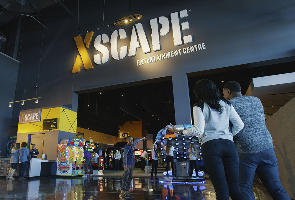 Photo of guests playing games in an XSCAPE arcade location in a Cineplex theater